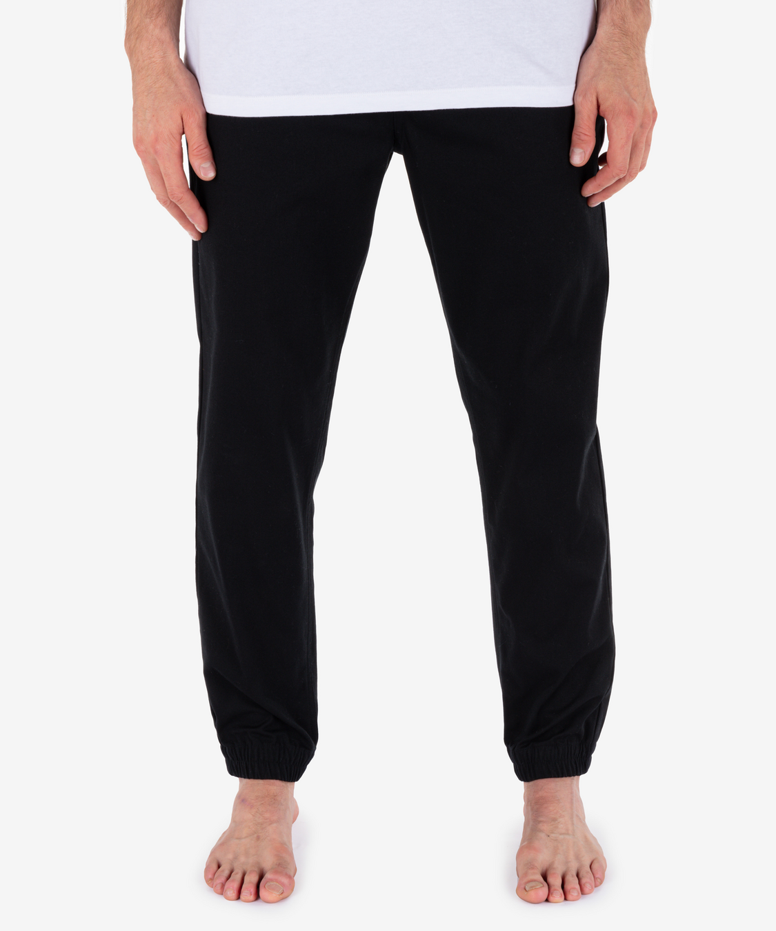 Black pants worn by a person on a white background