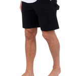 Person wearing black shorts on a white background