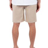 Person wearing beige shorts and a white shirt on a white background