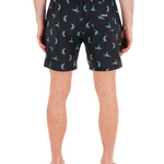 Person wearing black shorts with colorful flamingo pattern on a white background