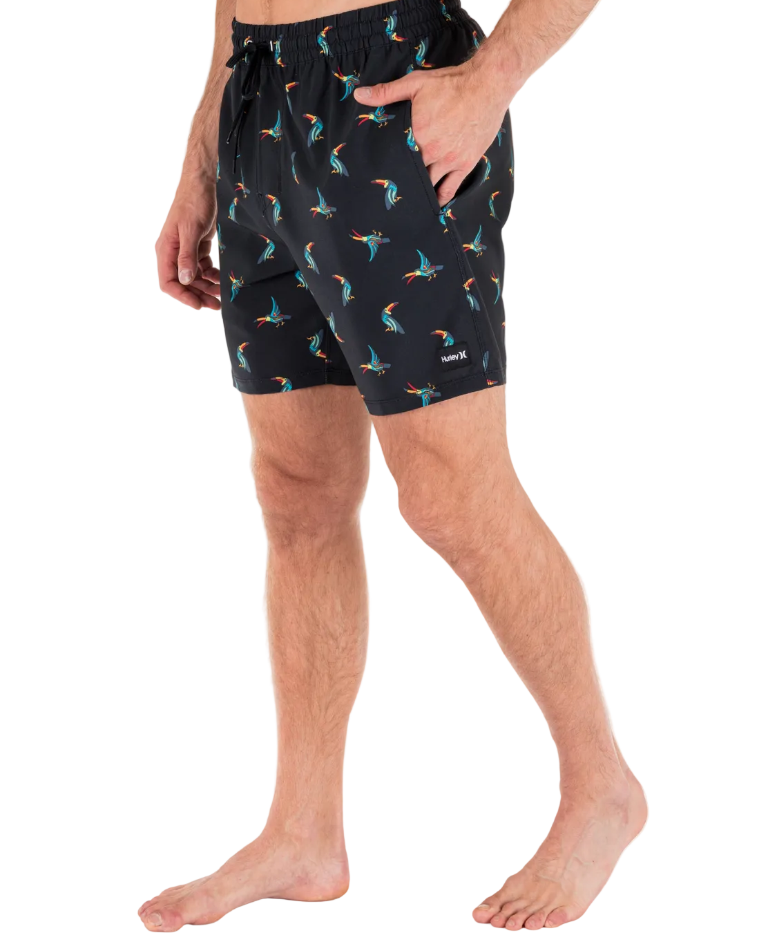 Person wearing black shorts with colorful bird pattern on a white background