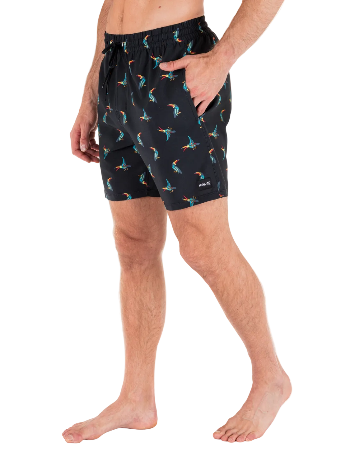 Person wearing black shorts with colorful bird pattern on a white background
