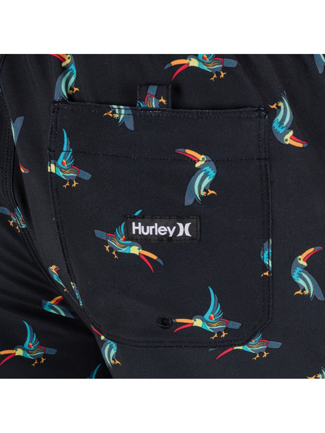 Close-up of a Hurley logo on a black background with colorful bird pattern