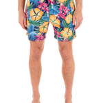 Person wearing colorful floral swim shorts on a white background