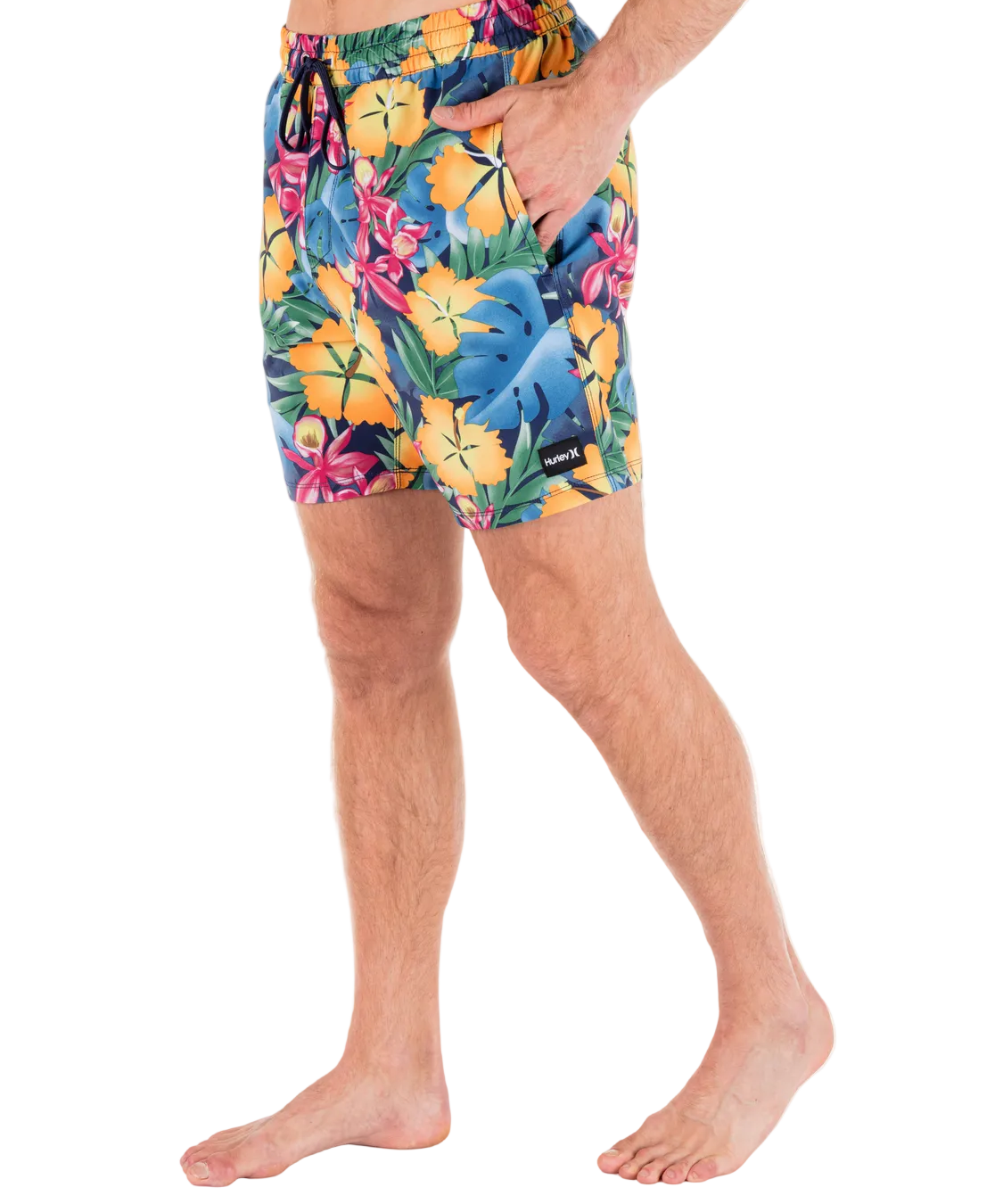 Person wearing colorful tropical floral swim shorts on a white background