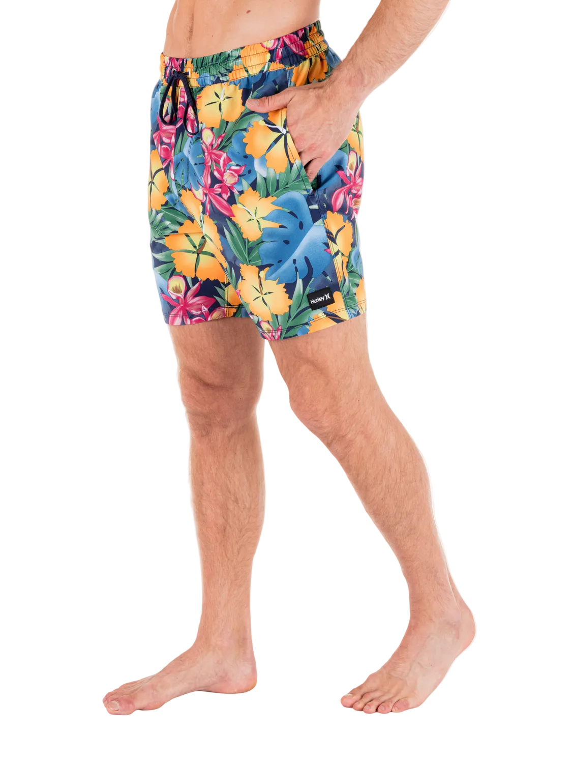 Person wearing colorful tropical floral swim shorts on a white background