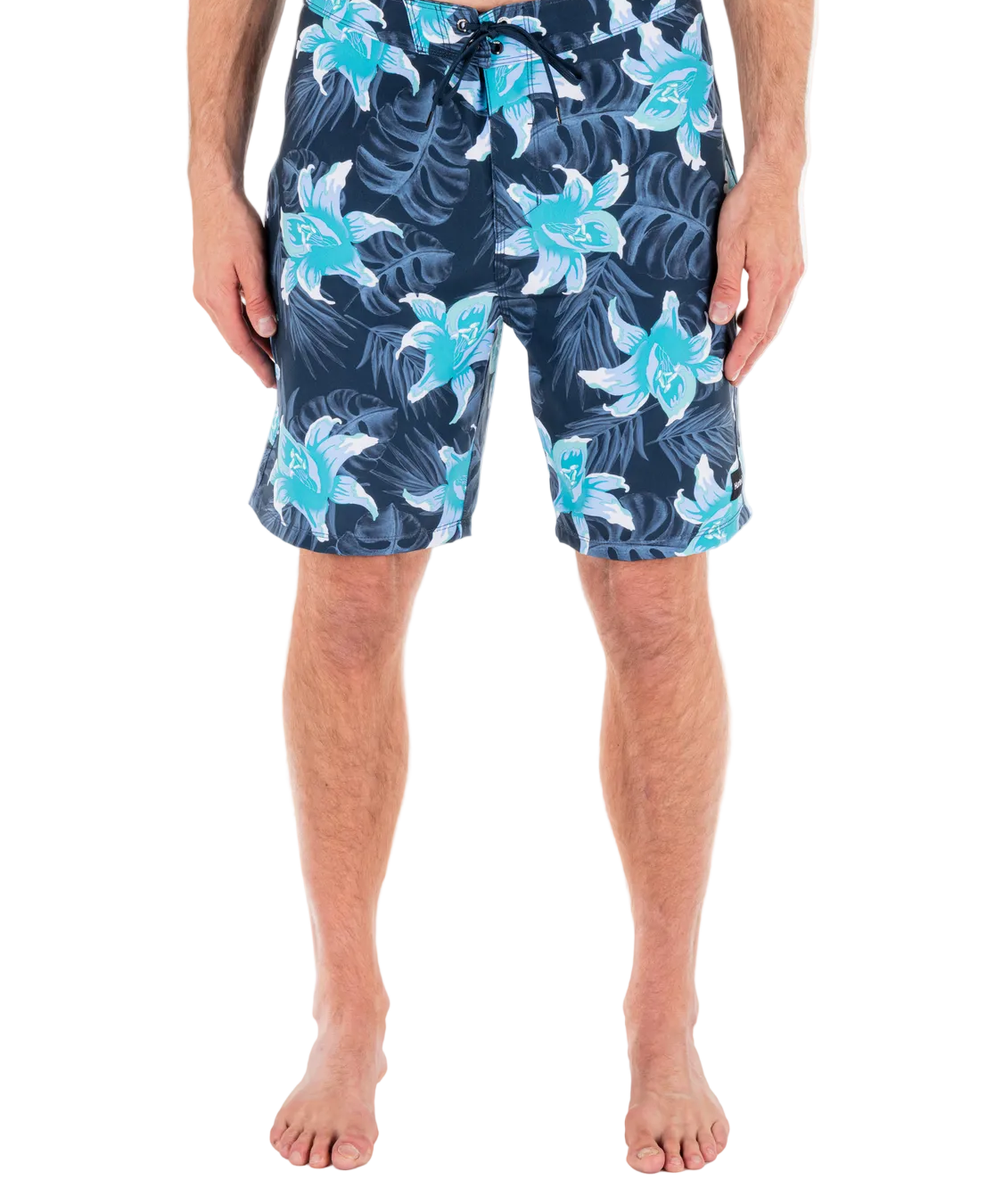 Person wearing navy shorts with blue floral patterns on a white background