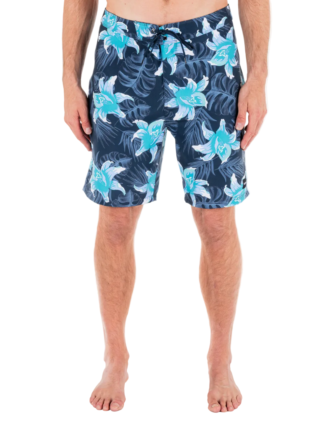 Person wearing navy shorts with blue floral patterns on a white background