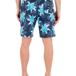 Person wearing blue floral swim shorts on a white background