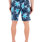 Person wearing blue floral swim shorts on a white background