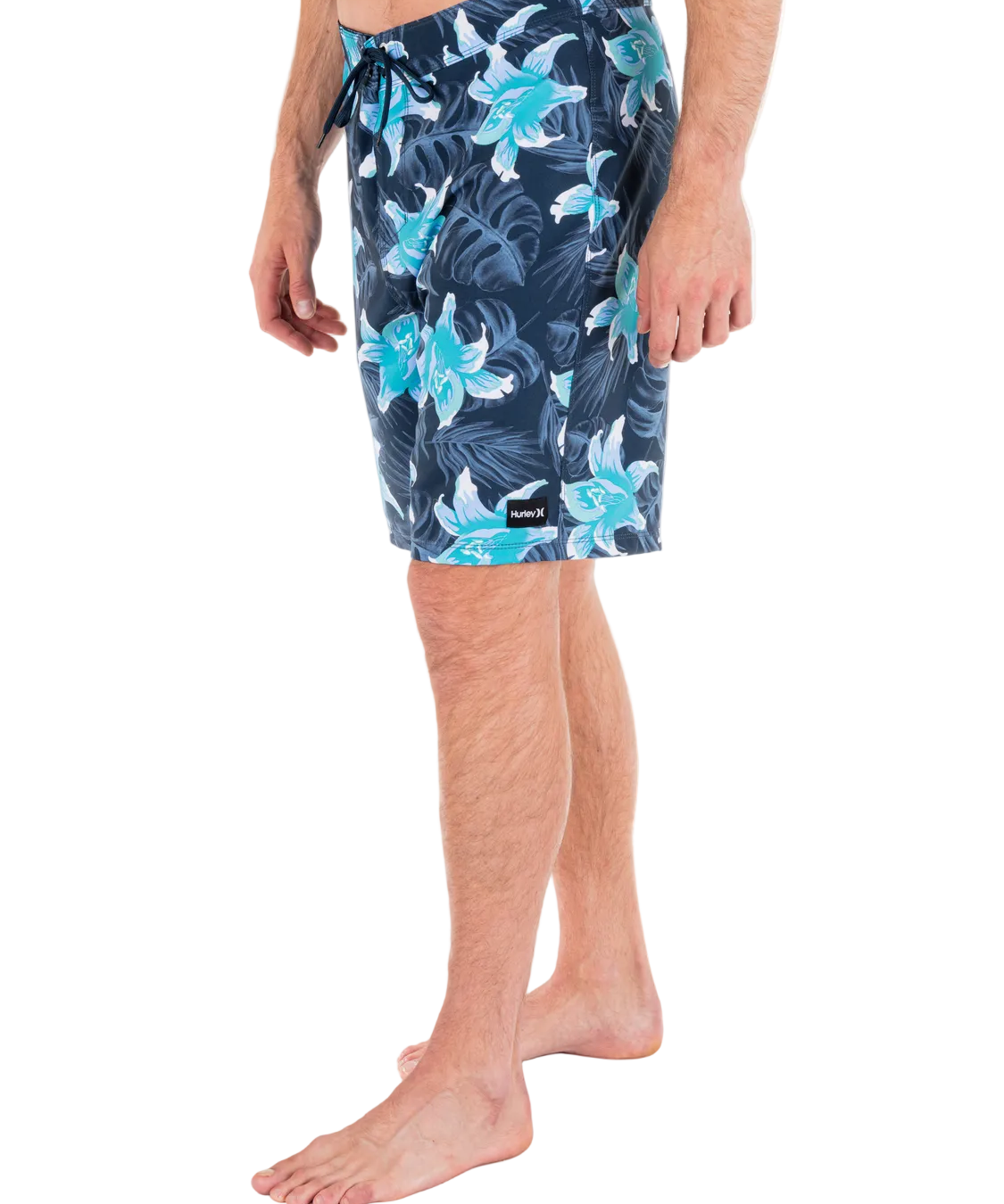 Person wearing navy floral swim shorts on a white background