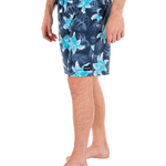 Person wearing navy floral swim shorts on a white background