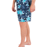 Person wearing navy floral swim shorts on a white background