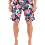 Person wearing colorful floral swim shorts on a white background