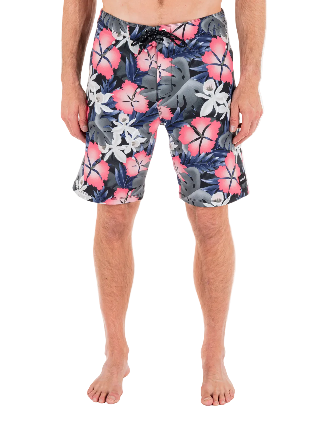 Person wearing colorful floral swim shorts on a white background