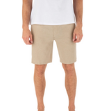 Person wearing beige shorts and a white shirt on a white background