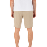Person wearing beige shorts and a white shirt on a white background