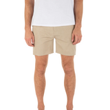 Person wearing beige shorts and a white shirt on a white background