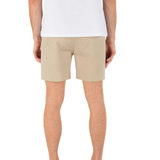 Person wearing beige shorts and a white shirt on a white background